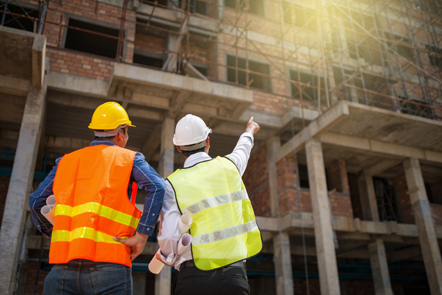 Construction engineers discussion with architects at construction site or building site of highrise building