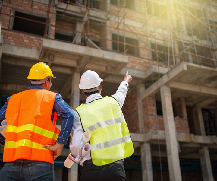 Construction engineers discussion with architects at construction site or building site of highrise building